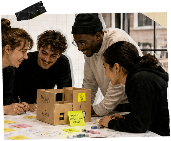 Une équipe qui travaille ensemble autour d’une maquette en carton et de post-it
